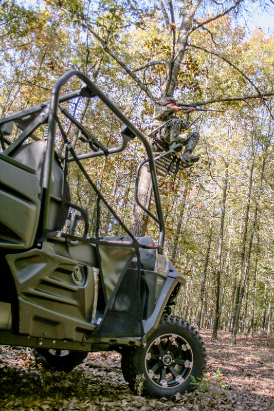 Man in treestand with UTV nearby