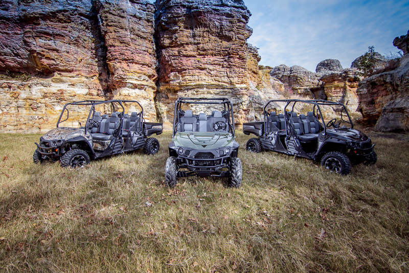Three UTVs in front of rock face.